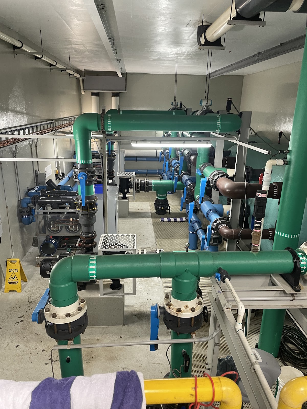 Commercial pool plant room with large green and blue pipework